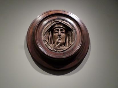 A carving of a face inside a circular frame of wood at the Dallas Museum of Art. 